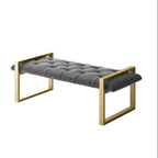 Gray upholstered bench with gold frame on a white background