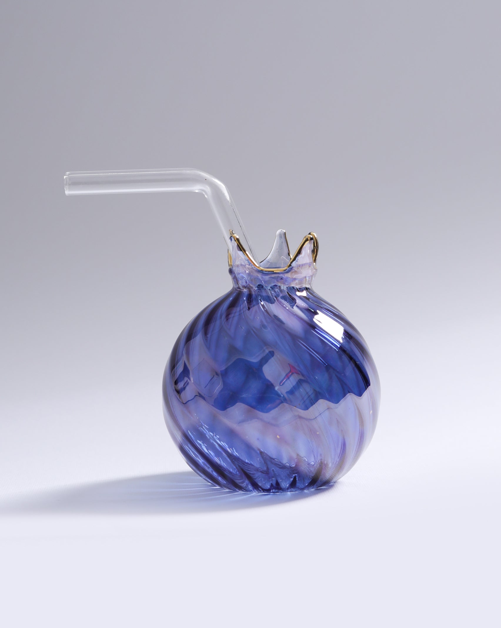 Blue glass drink container with a straw on a gray background