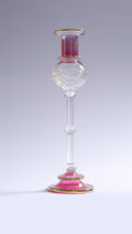 Decorative glass candlestick with pink and gold accents on a white background