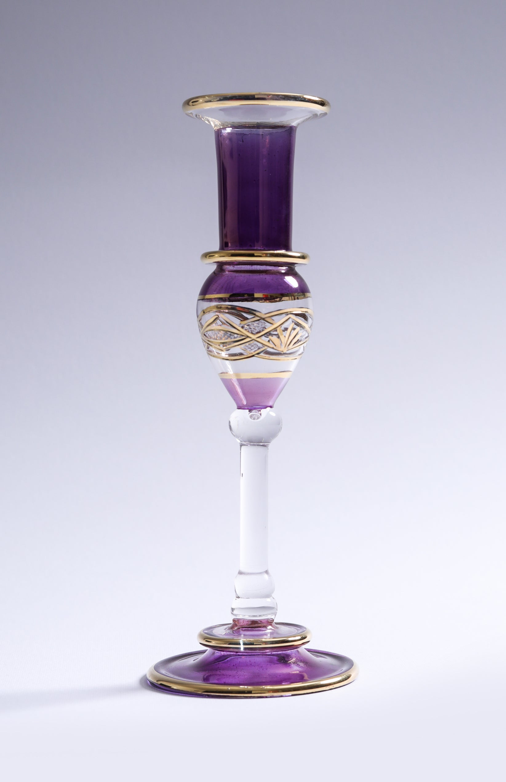 Decorative glass vase with purple and gold accents on a white background