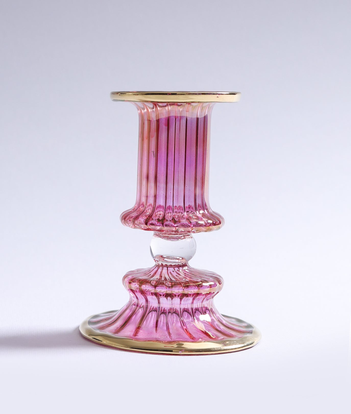 Pink glass candle holder on a white background