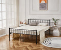 Black metal bed frame in a bedroom with wooden flooring and decorative elements.