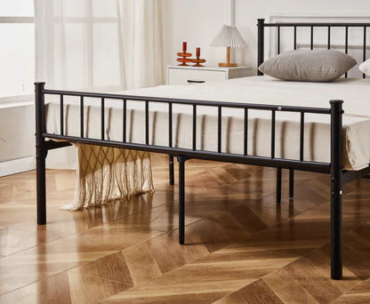 Black metal bed frame with white bedding in a bedroom setting.