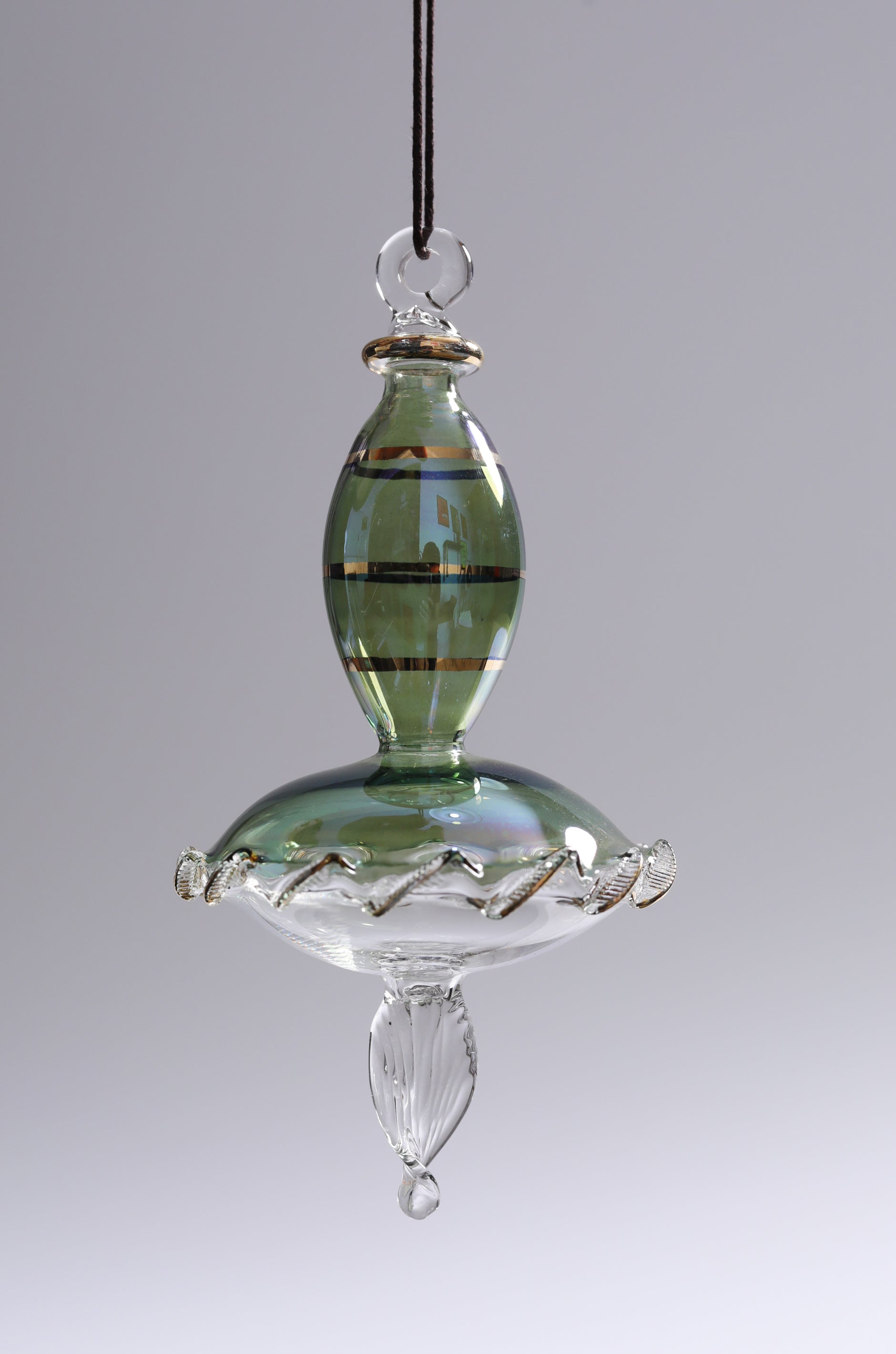 Glass hanging ornament with green and clear sections on a gray background