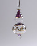 Decorative glass hanging ornament with purple top and gold accents on a gray background