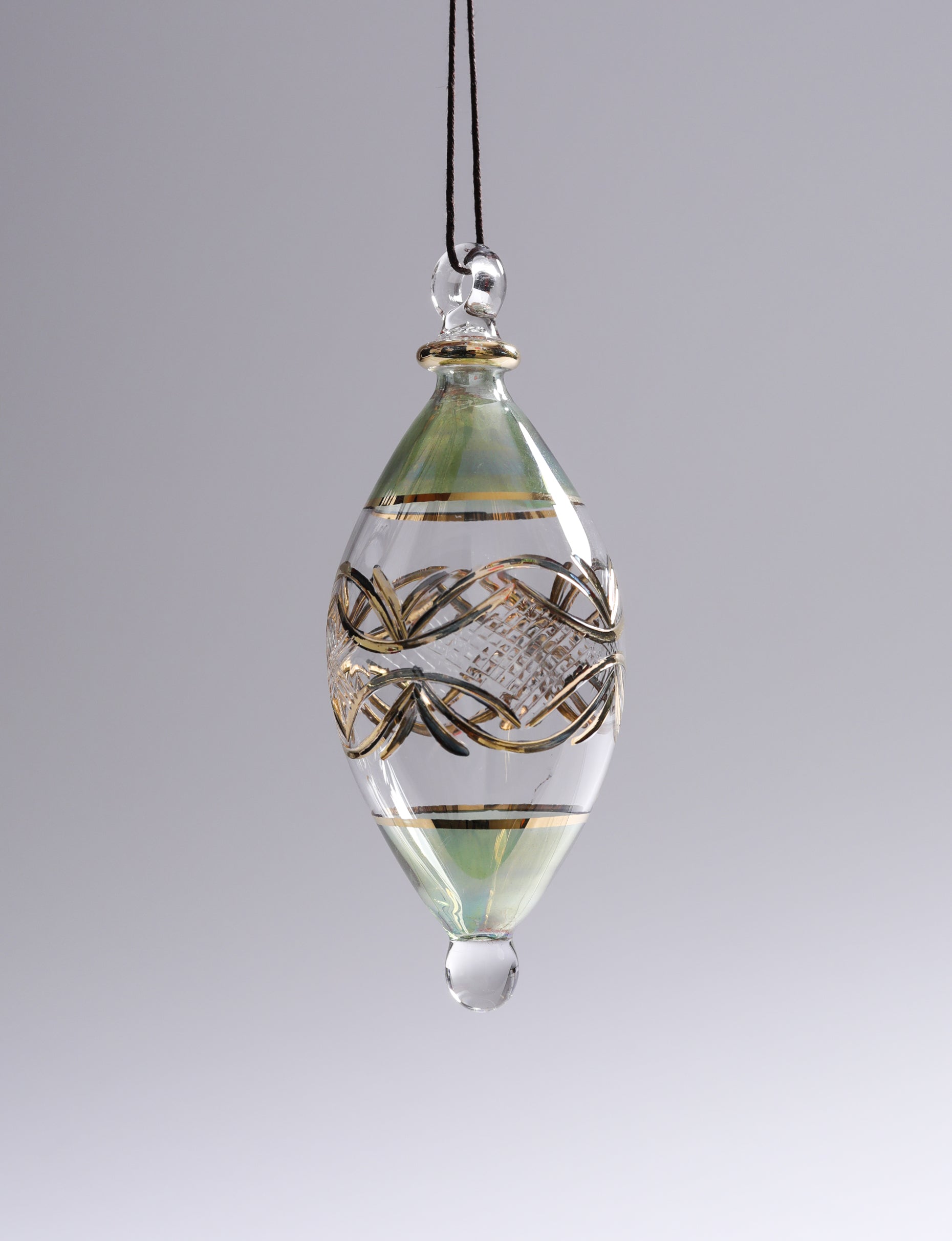 Decorative glass pendant with intricate patterns on a gray background