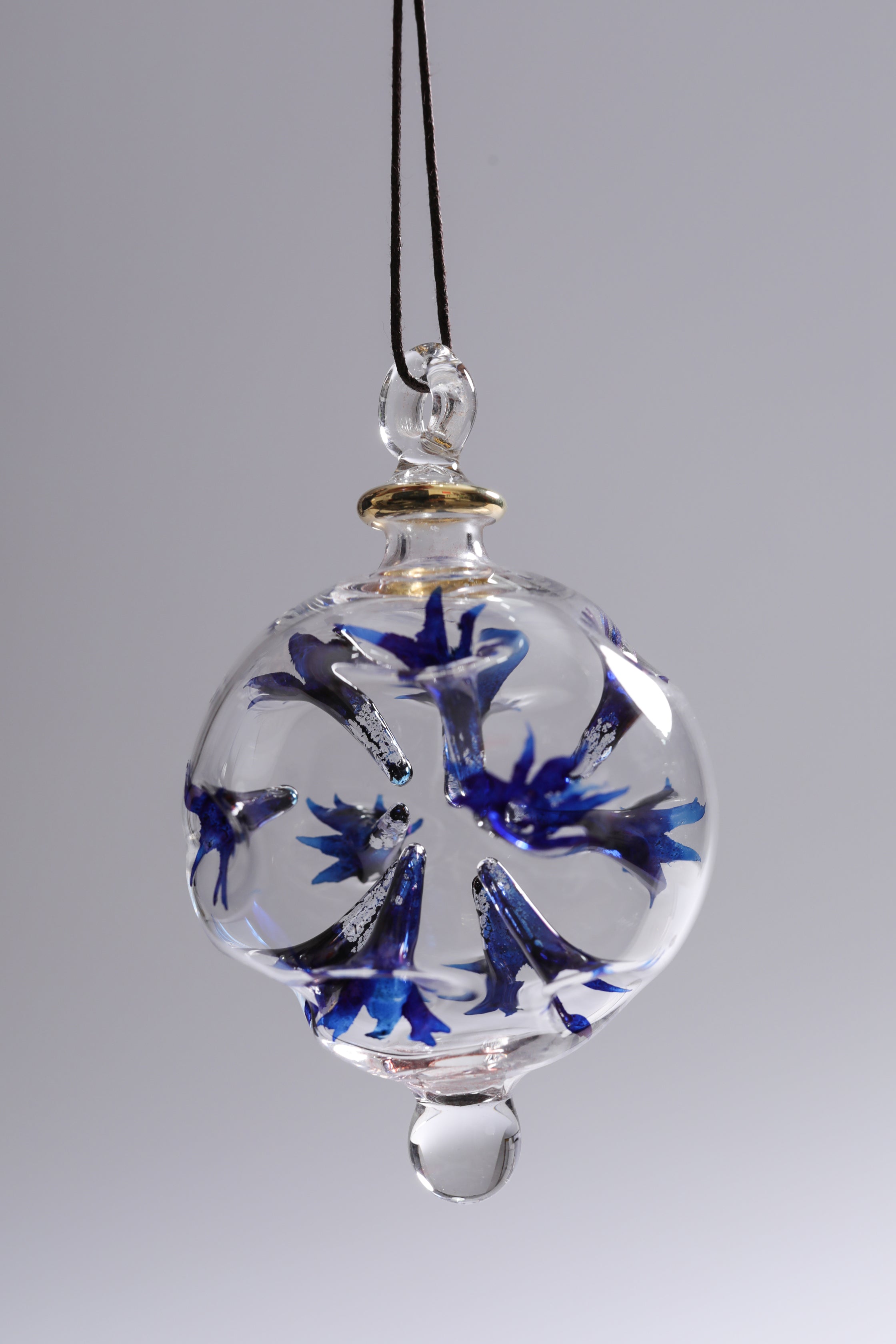 Glass ornament with blue floral design on a gray background