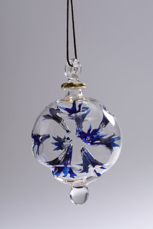 Glass ornament with blue floral design on a gray background