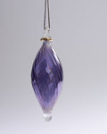 Purple glass hanging ornament on a gray background