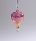 Pink and yellow glass ornament on a gray background