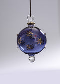 Decorative glass ornament with star designs on a plain background