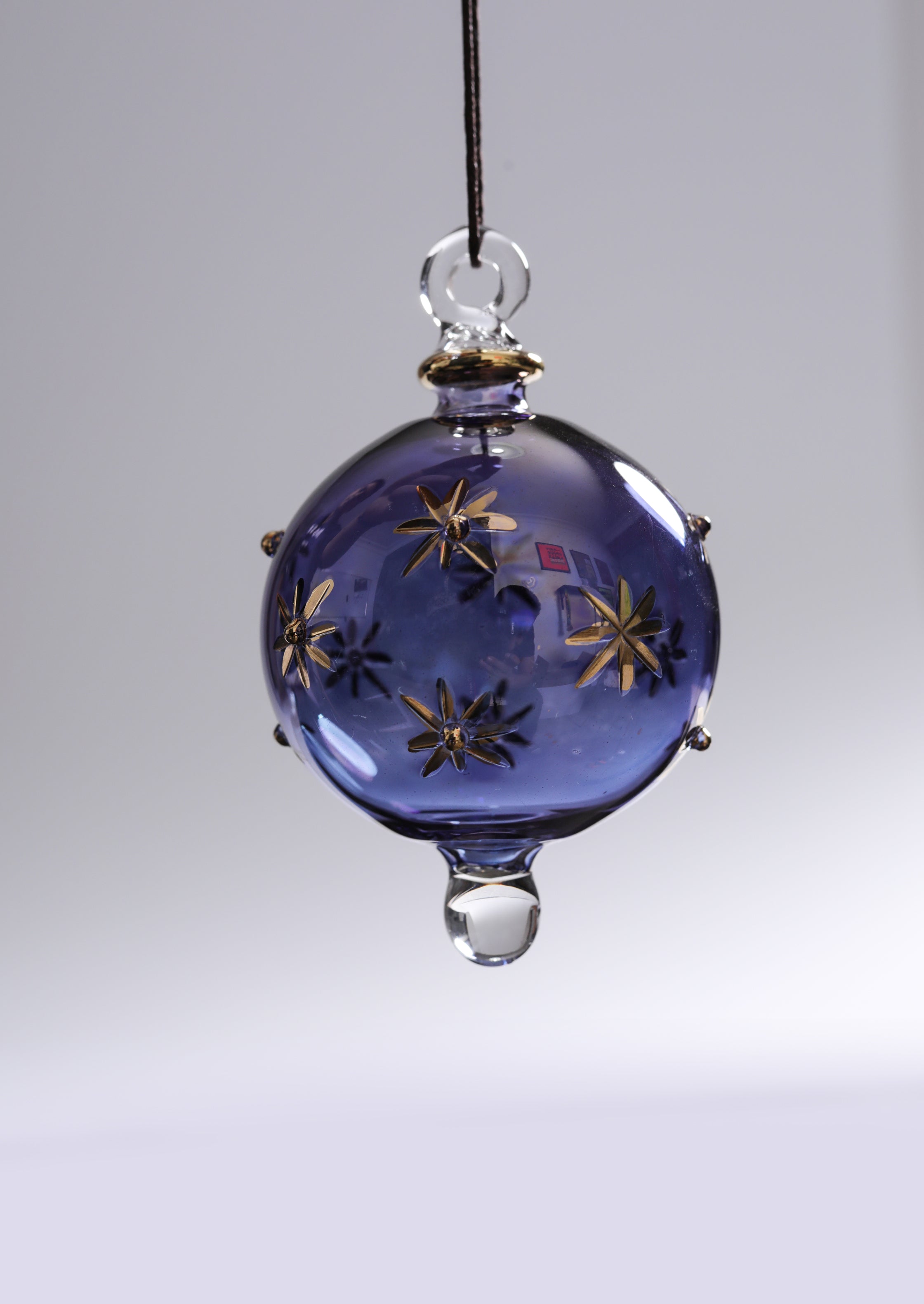 Decorative glass ornament with star designs on a plain background