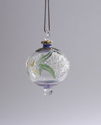 Decorative glass ornament with floral design on a gray background