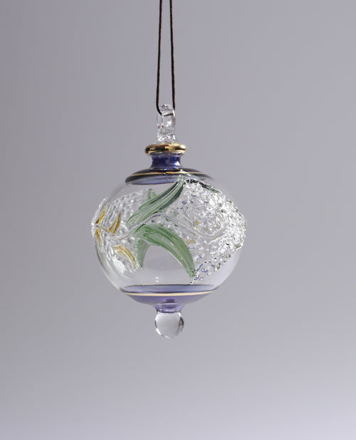 Decorative glass ornament with floral design on a gray background