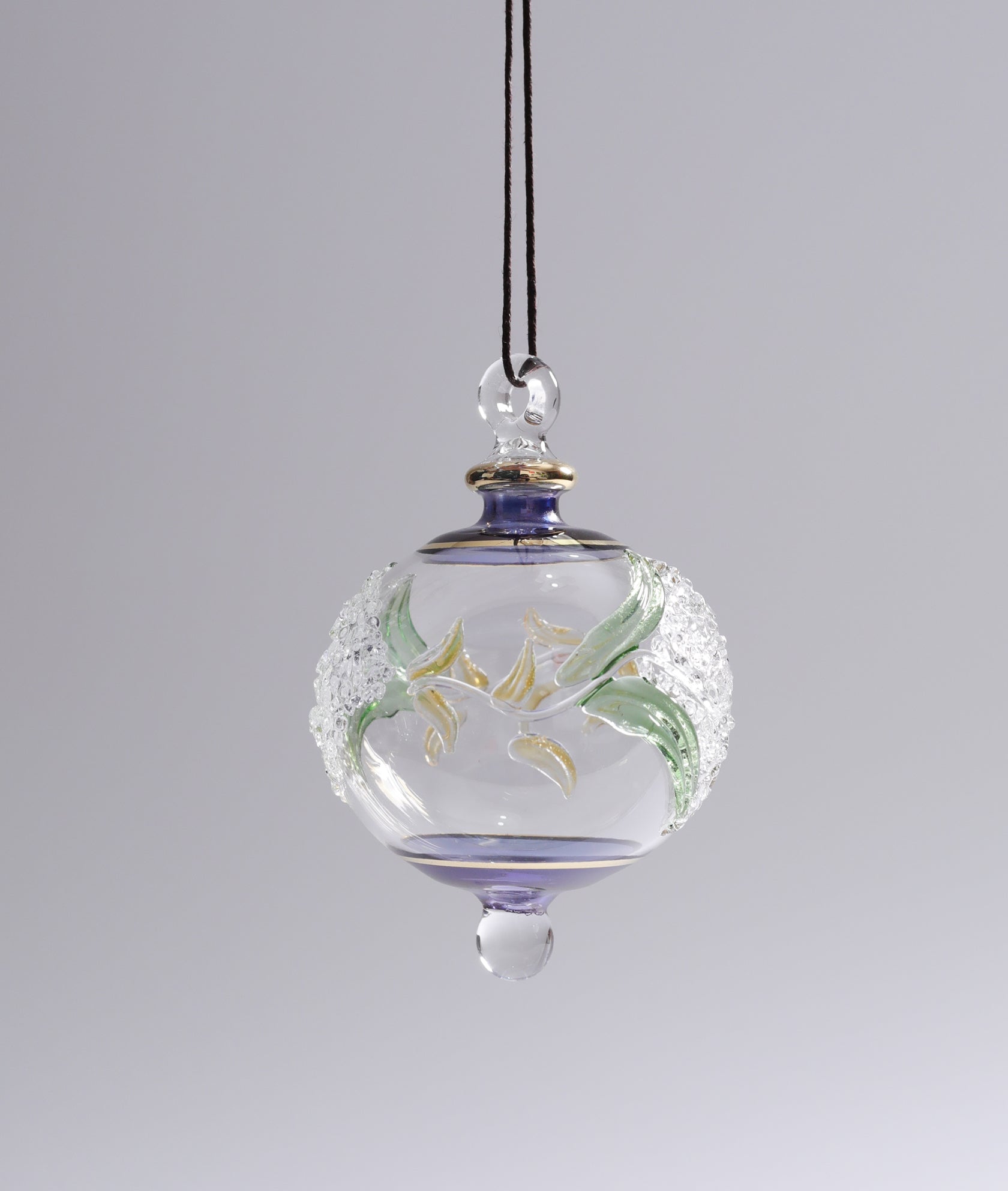 Decorative glass hanging ornament with floral design on a plain background