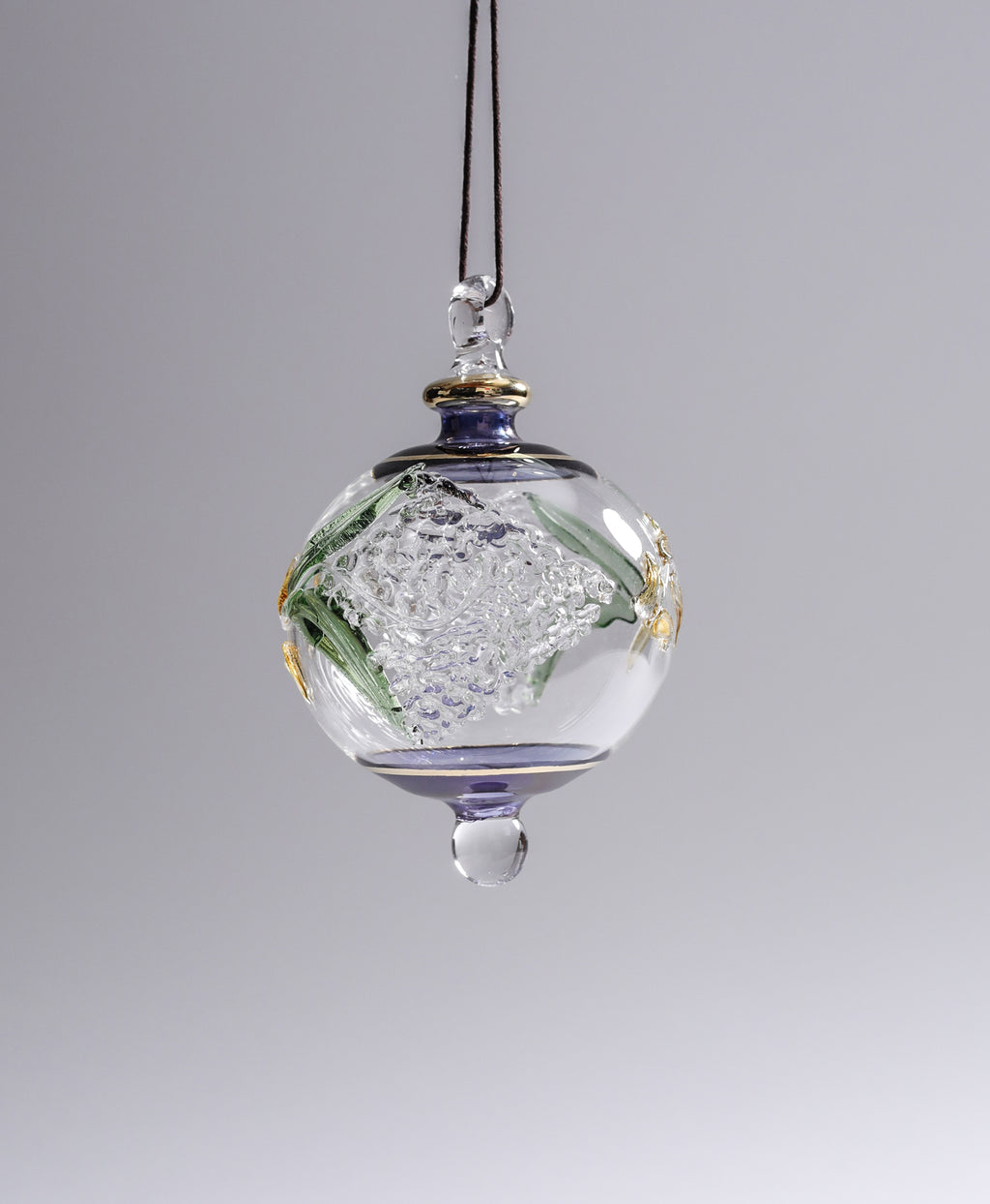 Decorative glass hanging ornament with floral design on a gray background