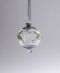 Decorative glass hanging ornament with floral design on a gray background