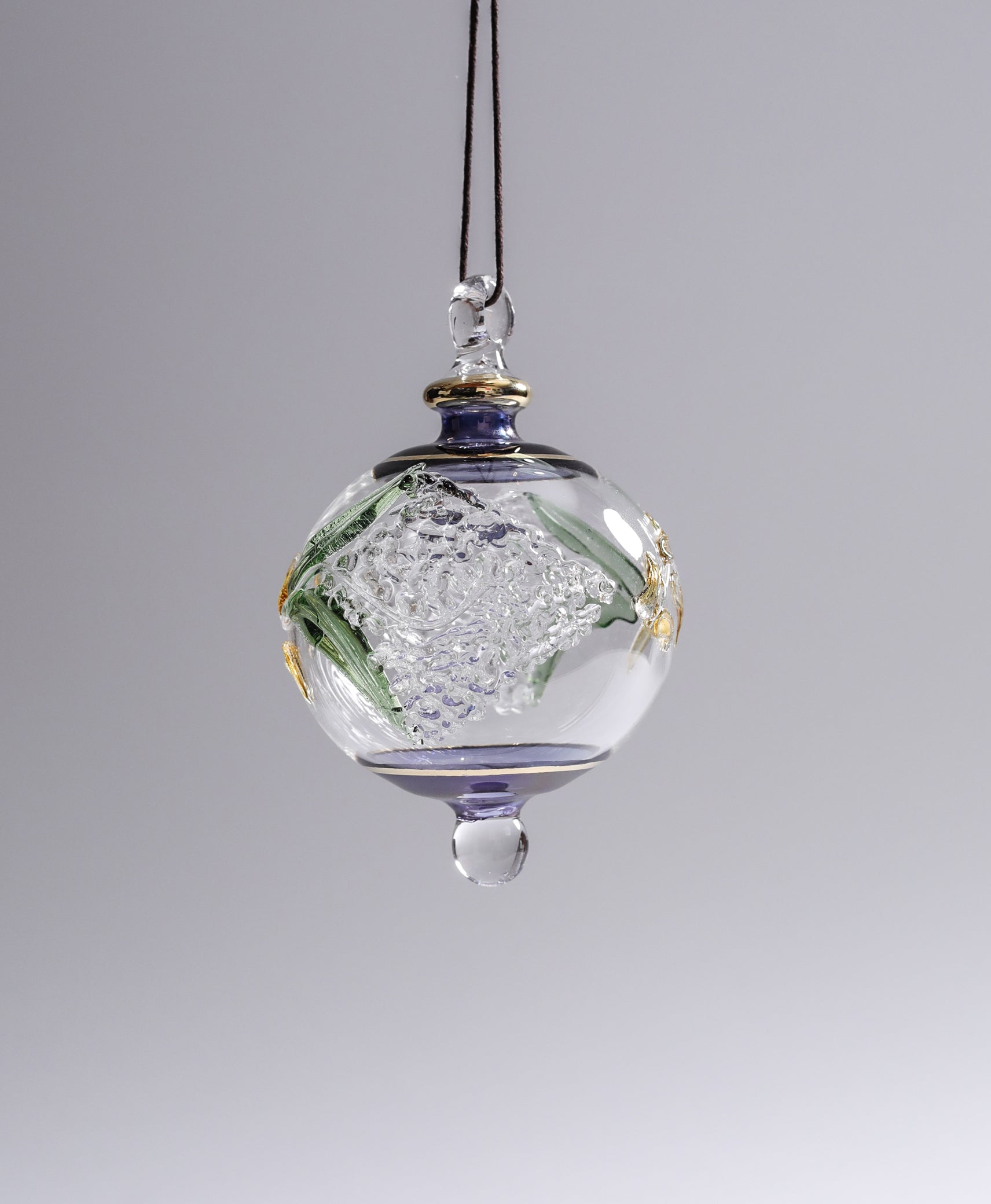 Decorative glass hanging ornament with floral design on a gray background