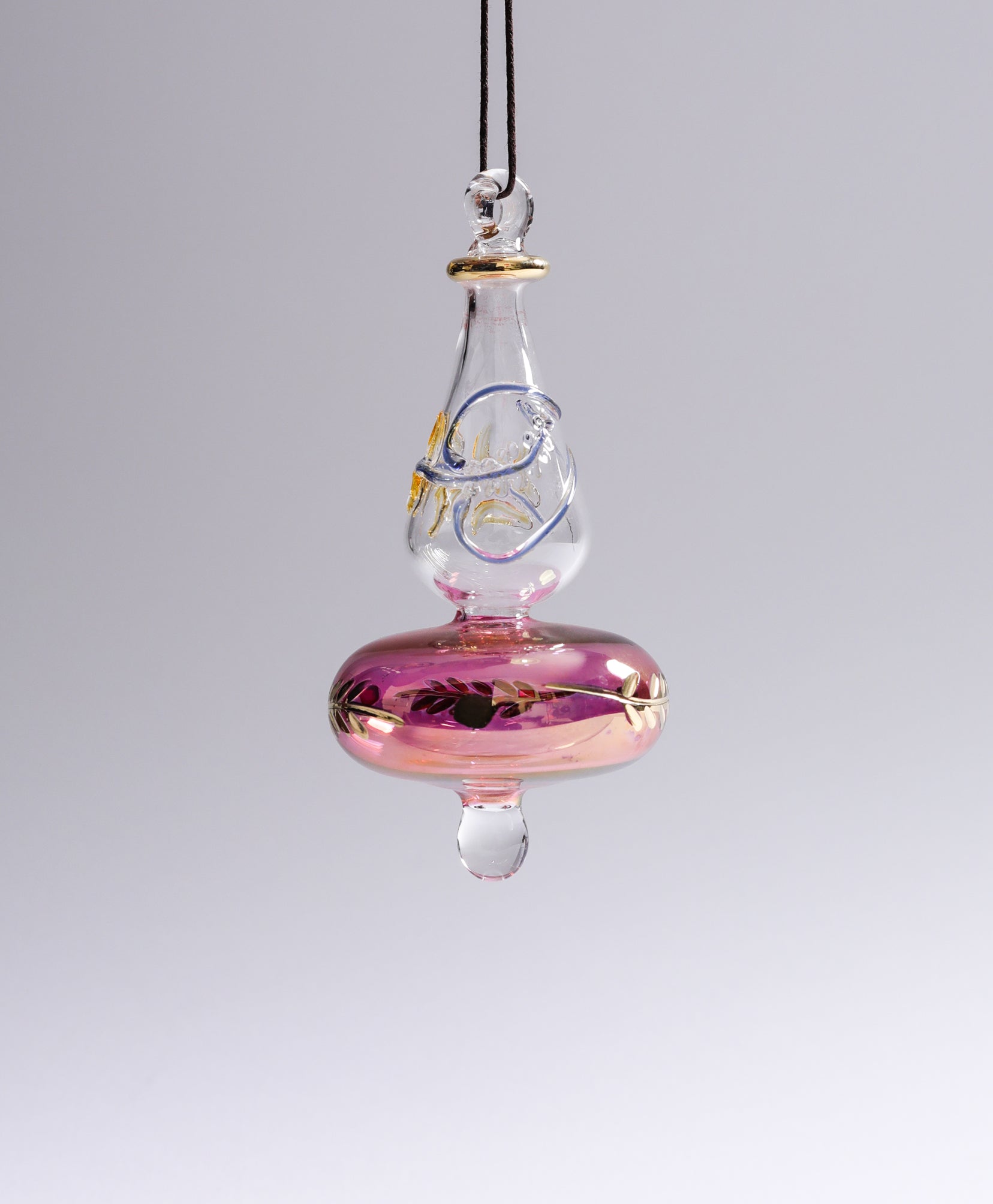 Glass ornament with pink base and clear top on a gray background