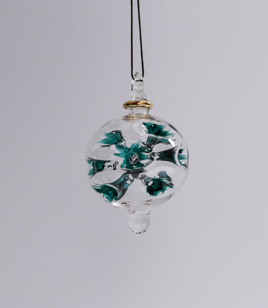 Decorative glass ornament with floral design on a gray background