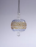Decorative glass ornament with gold and blue patterns on a gray background