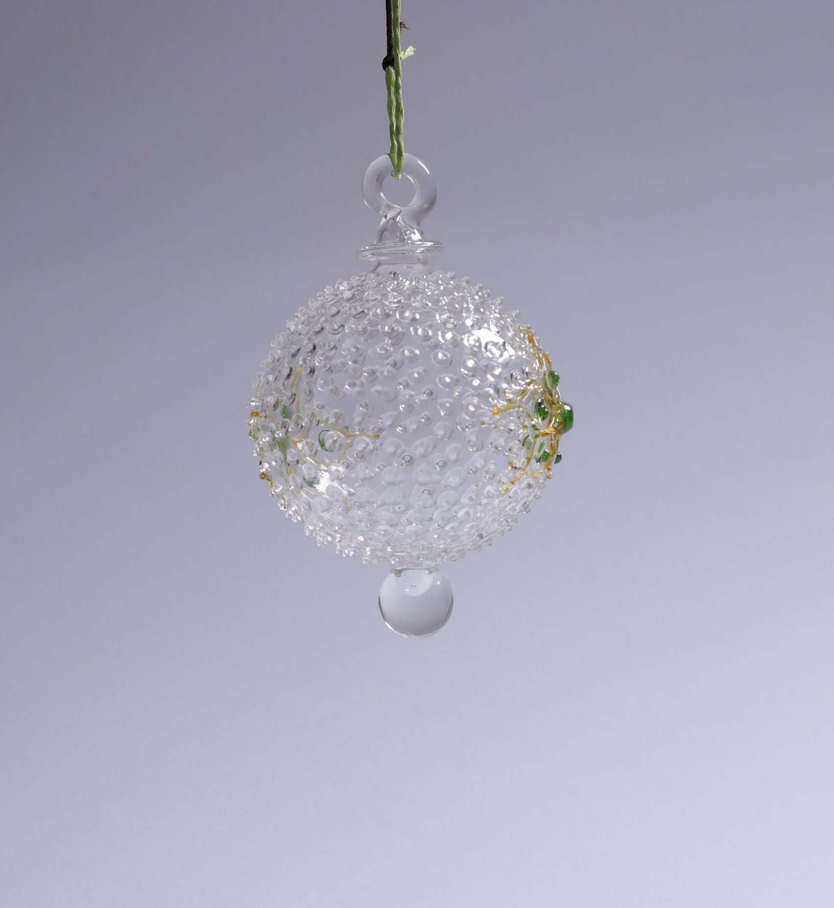 Decorative glass ball hanging against a gray background