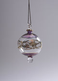 Decorative glass ornament with floral design on a gray background