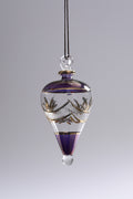 Glass pendant with purple and gold accents on a gray background