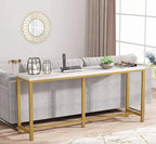 Modern living room with a gold console table, gray sofa, and decorative mirror.