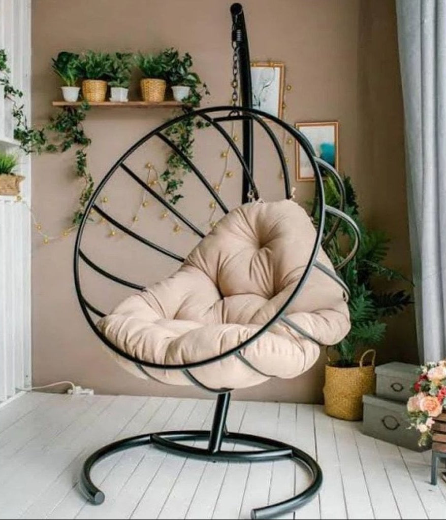 Hanging chair with beige cushion in a room with plants and decor