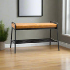 Bench with orange cushion in a room with a plant and framed picture on the wall.