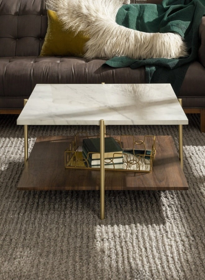 Modern coffee table with marble top and gold legs in a living room setting.