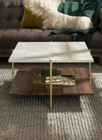 Modern coffee table with marble top and gold legs in a living room setting.