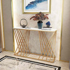 Decorative console table with marble top and gold lattice design against a wall with framed art.