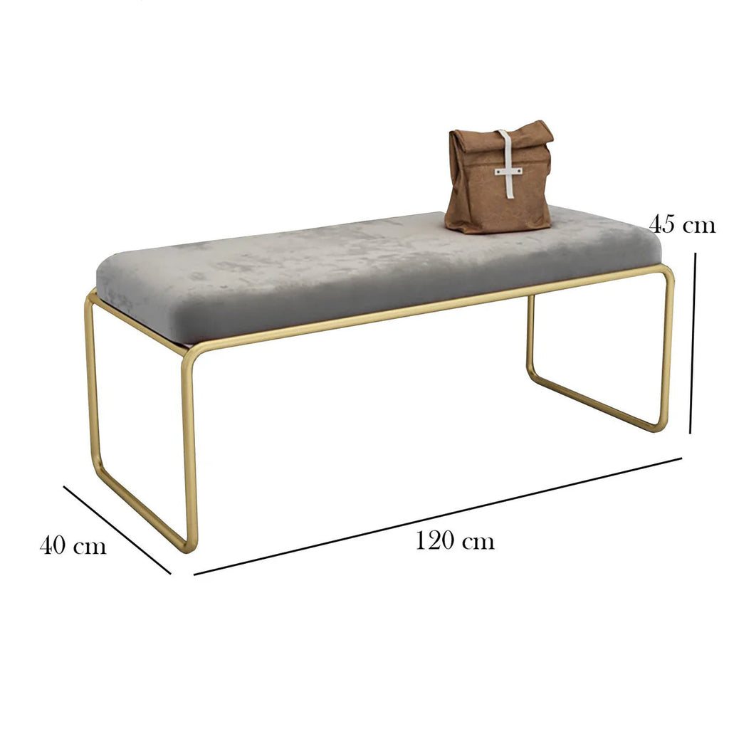 Gray cushioned bench with gold legs and a brown bag on top, with dimensions labeled.