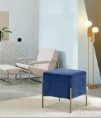 Modern living room with a beige armchair, blue ottoman, and gold floor lamp.