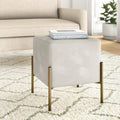 Beige cube side table with gold legs in a living room setting