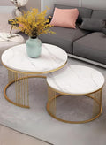 Two marble coffee tables with gold metal frames in a living room setting.