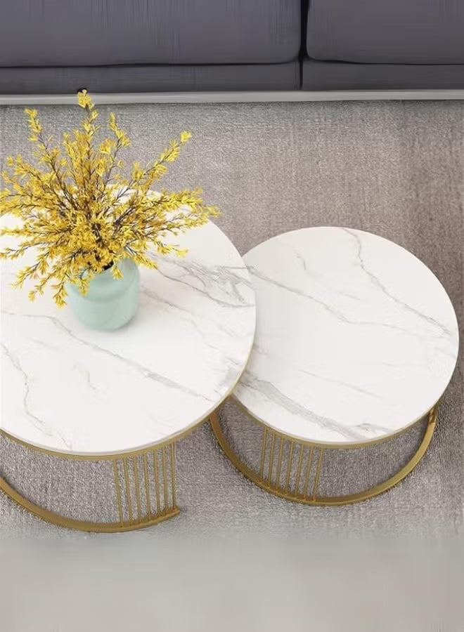 Marble coffee table with gold legs and a vase of yellow flowers on a gray carpet.