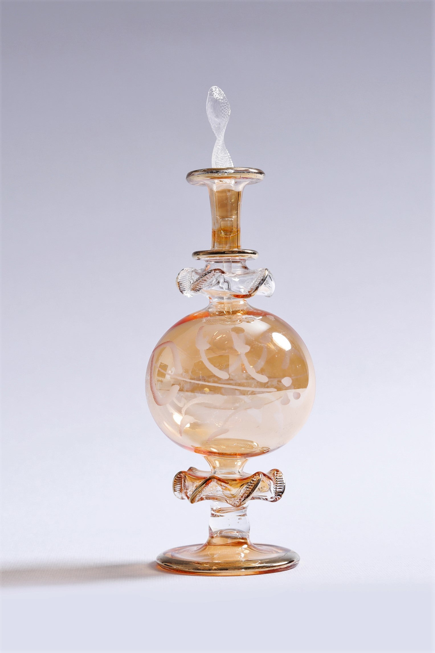 Glass decanter with a stopper on a light gray background