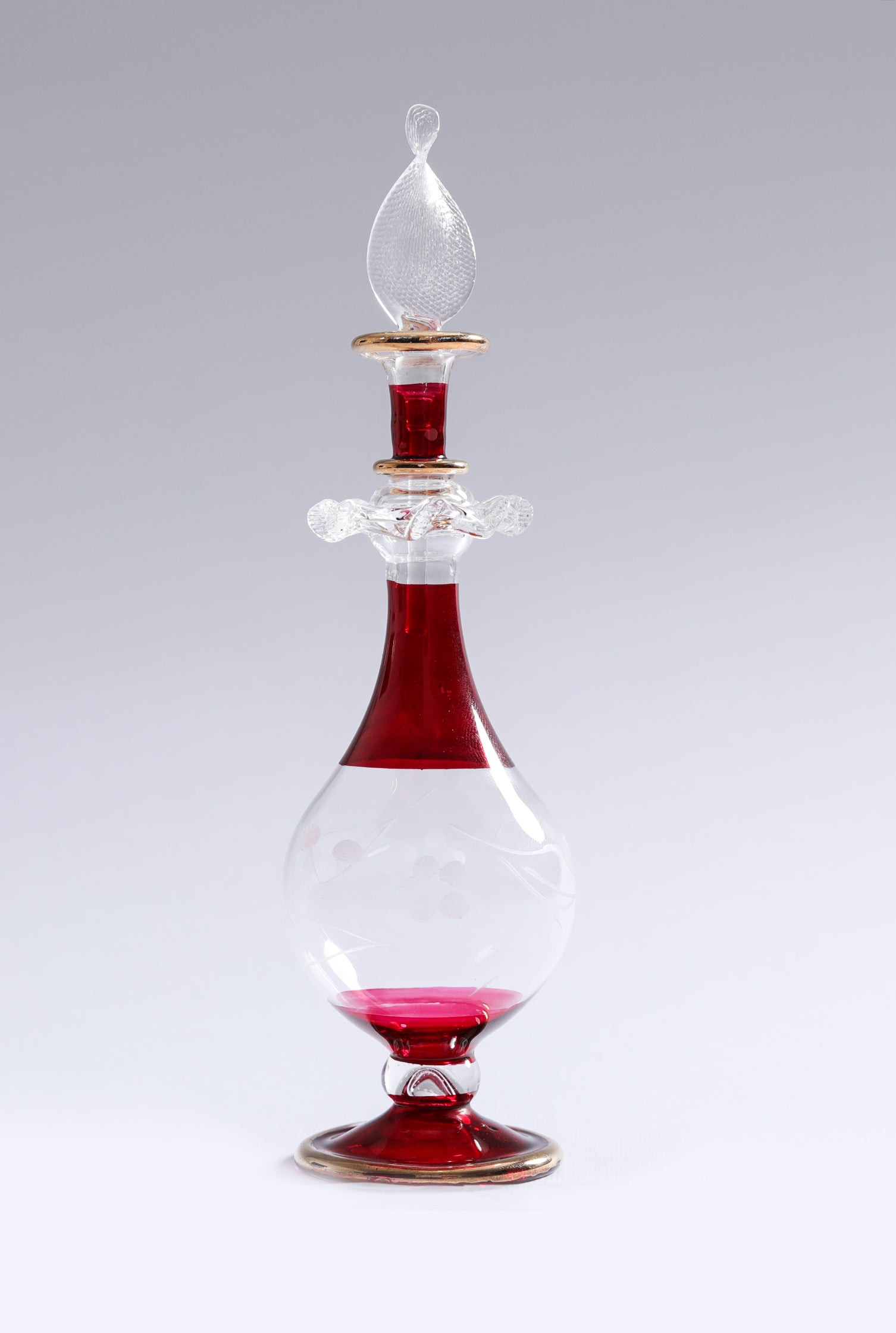 Glass decanter with red liquid on a white background