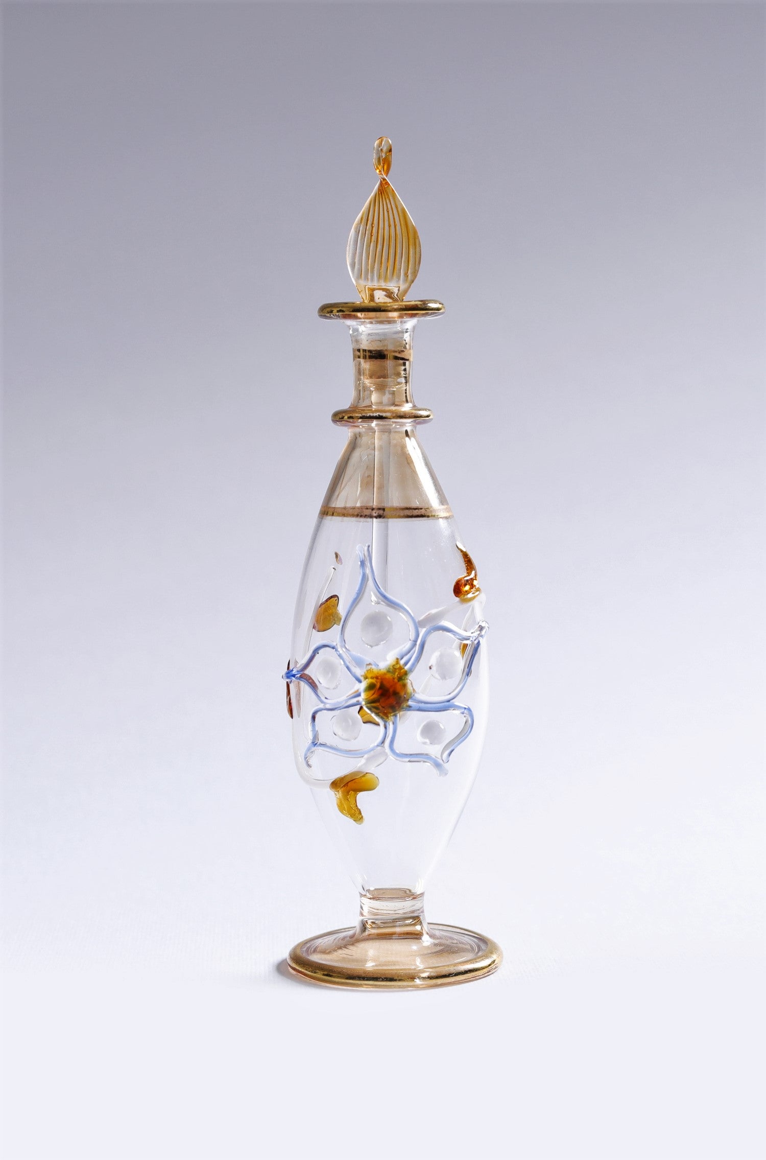 Decorative glass bottle with gold accents on a gray background