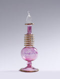 Pink glass bottle with a decorative neck on a gray background