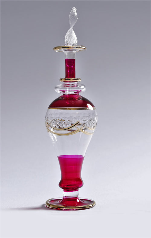 Decorative glass bottle with red and clear sections on a gray background