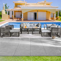 Outdoor patio furniture set by a pool with a house in the background
