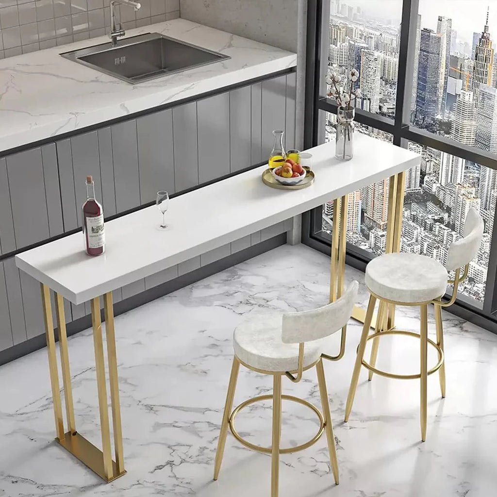 Modern kitchen bar with white countertop, gold legs, and stools in a cityscape view.