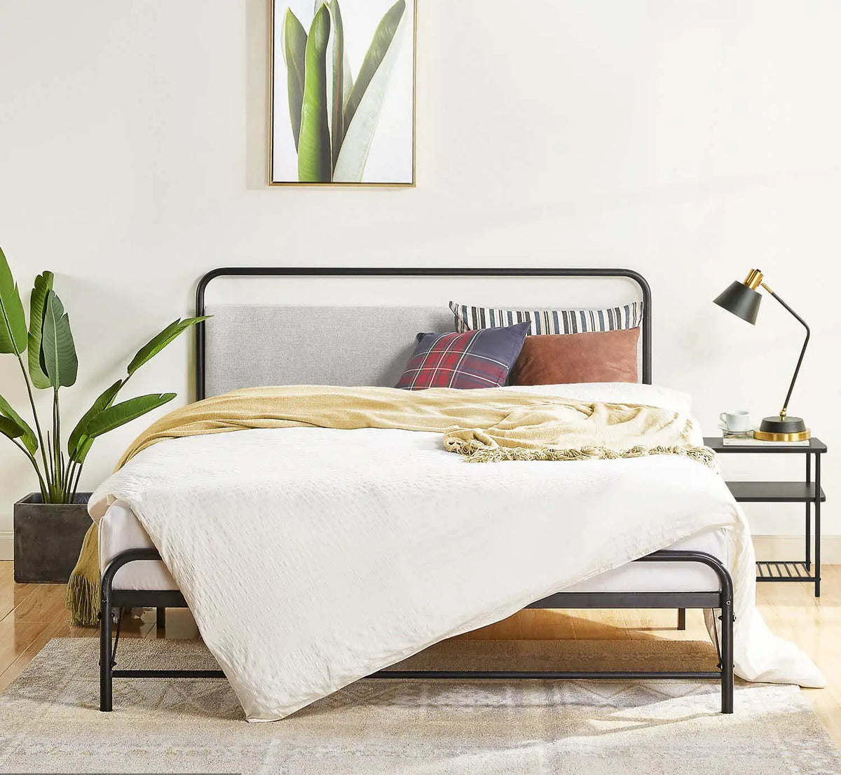 Bedroom with a bed, pillows, and a lamp on a nightstand.