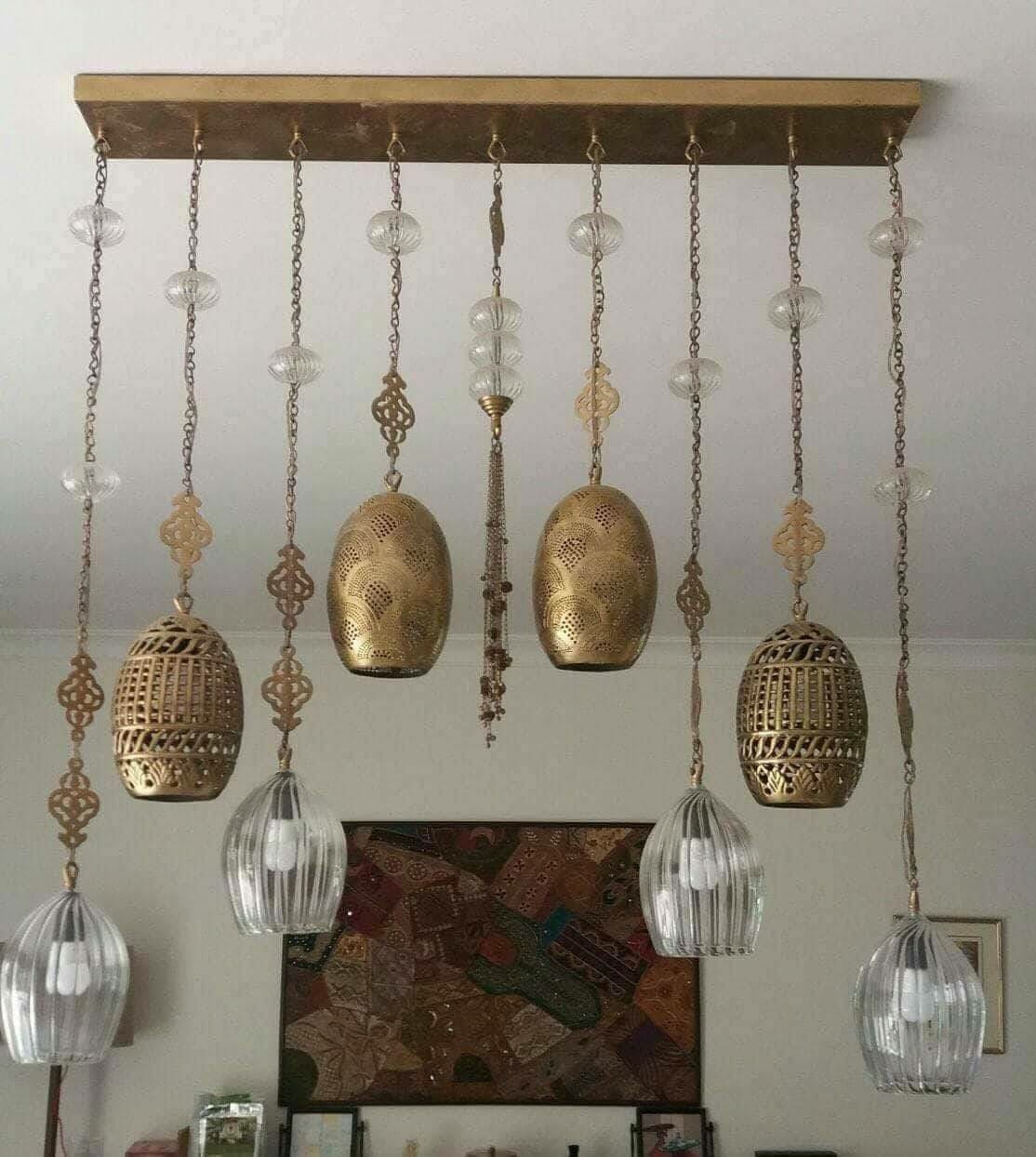 Decorative ceiling light fixture with hanging gold and glass elements.
