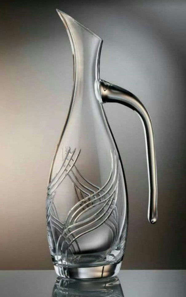 Glass carafe with artistic etching on a reflective surface