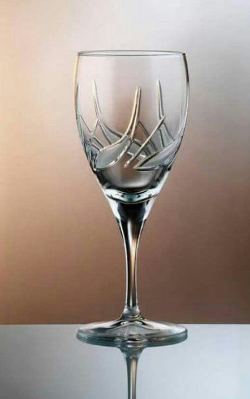 Clear glass wine glass with intricate design on a reflective surface